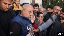Wael Al-Dahdouh, șeful biroului Al Jazeera din Gaza, își îmbrățișează fiica în timpul înmormântării fiului său, Hamza, pe 7 ianuarie 2024. Tânărul jurnalist a fost ucis într-un atac aerian israelian la Rafah, în Fâșia Gaza.