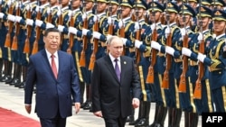 Ruski predsjednik Vladimir Putin pored počasne garde sa Si Đinpingom, u Pekingu prošle godine. Novi izveštaj navodi da je Kina zaobilazila sankcije EU snabdjevajući Moskvu brojnom robom koja se koristi u vojne svrhe. (arhivska fotografija)