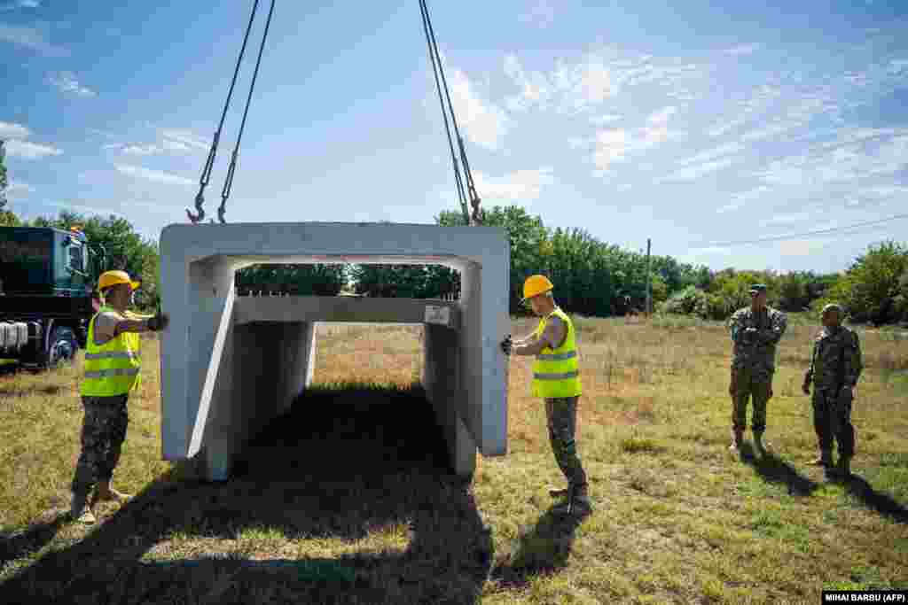 Romanian soldiers begin construction of a bomb shelter for residents of the village of Plauru, in the Danube Delta, some 300 kilometers east of Bucharest, on September 12. Romania's Defense Ministry ordered the structures to be built after drone fragments were found over the weekend.