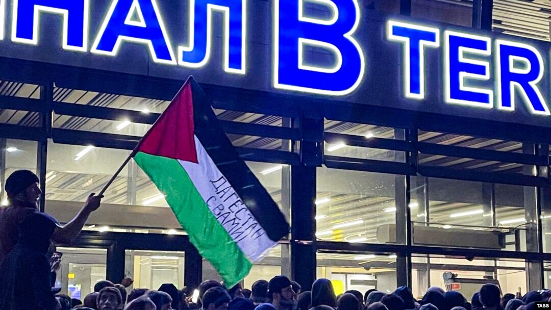 Lokalni čovjek maše palestinskom zastavom s porukom "Dagestan s vama", na aerodromu Mahačkala, Dagestan, Ruska Federacija, 29. 10. 2023.