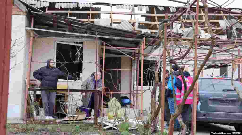 Emergency responders and aid workers speak with local residents whose homes were damaged during the Russian missile strike. President Volodymyr Zelenskiy said the assault involved 150 drones and missiles and once more appealed to Ukraine's allies to speed up deliveries of critically needed ammunition and weapons systems.