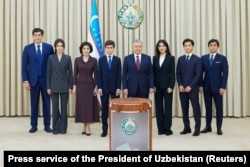 Shavkat Mirziyoev (center) and his family members pose during voting in an early presidential election in July 2023.