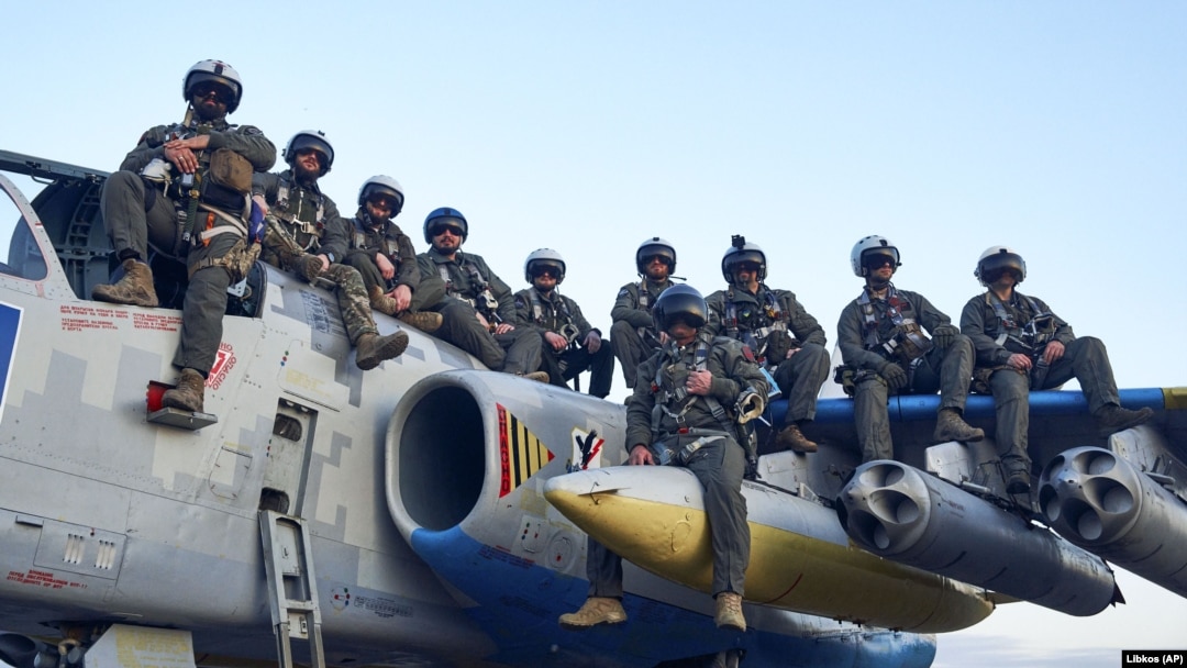 Пілоти Повітряних сил ЗСУ позують для фото, сидячи на штурмовику Су-25, на своїй базі на сході України, 4 травня 2023 року