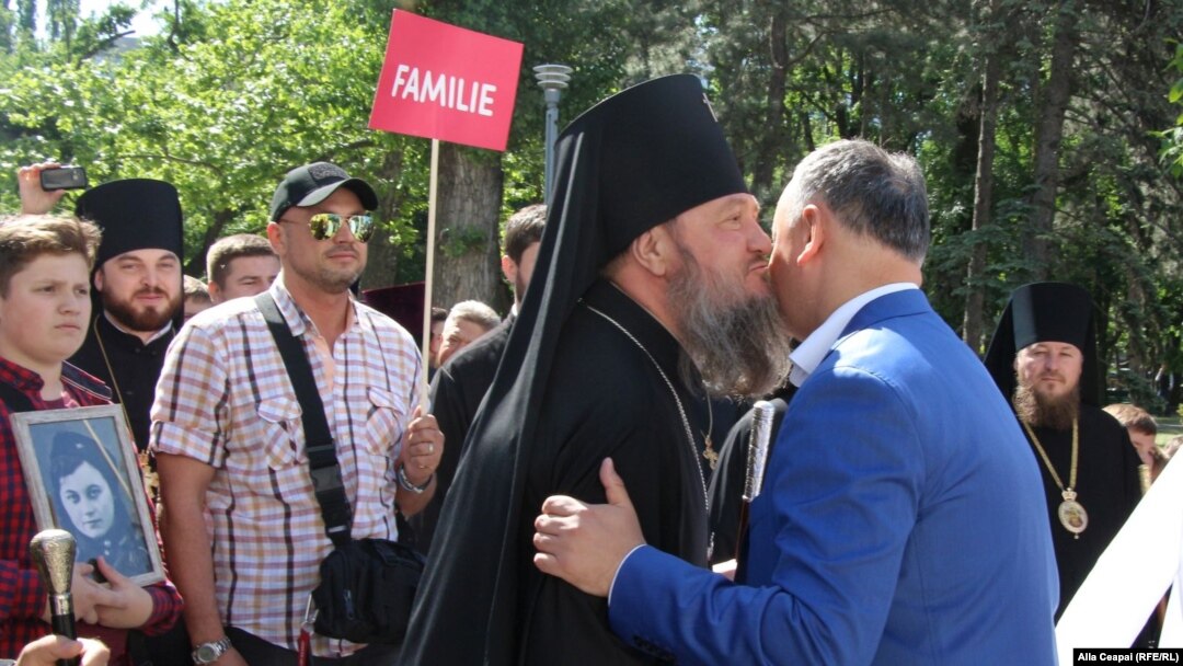 Moldovan President Igor Dodon (right) greets an Orthodox bishop during an anti-LGBT march in Chisinau on May 12.