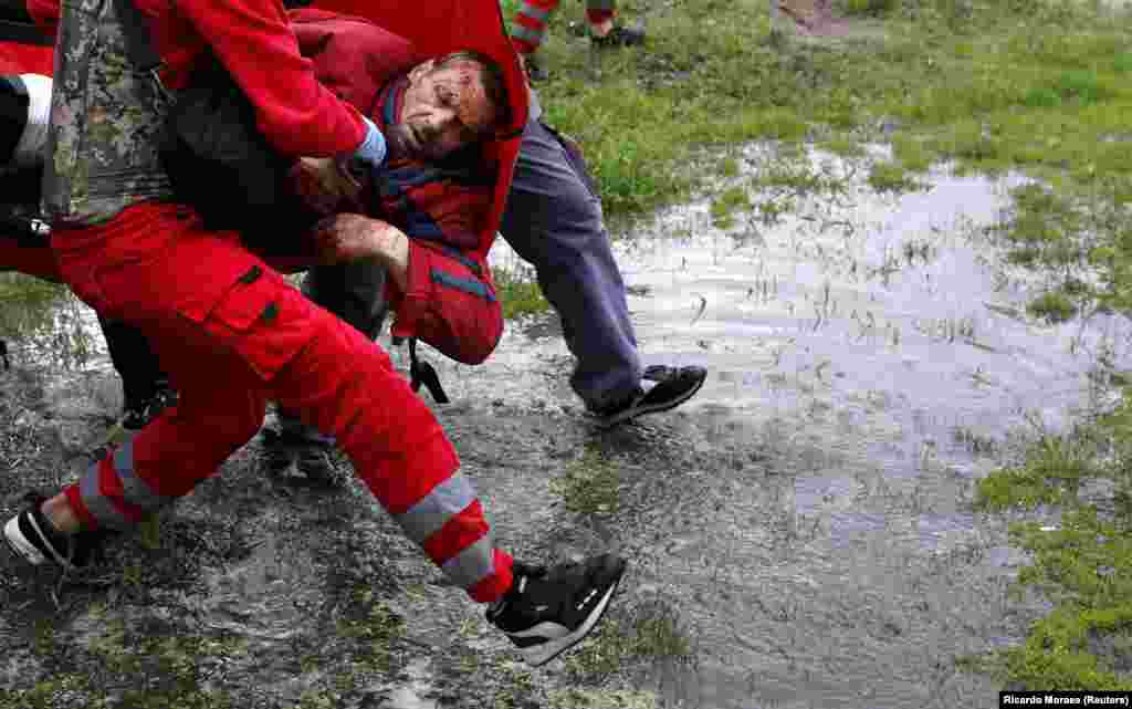 Medical workers carry an injured man following shelling in Kharkiv on April 27. 