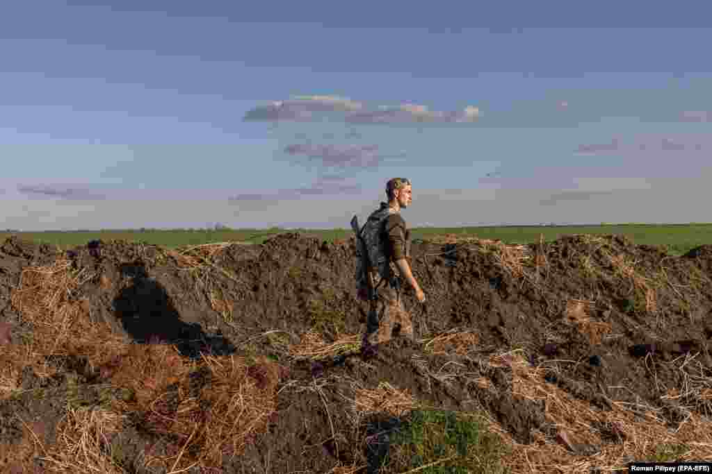 A Ukrainian serviceman walks in a trench alongside a checkpoint in the Zaporizhzhya region on April 27. 