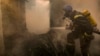 Un pompier ucrainean pulverizează apă pe o casă distrusă miercuri de obuze în Kiev, 23 martie 2022. (AP Foto/Vadim Ghirda)