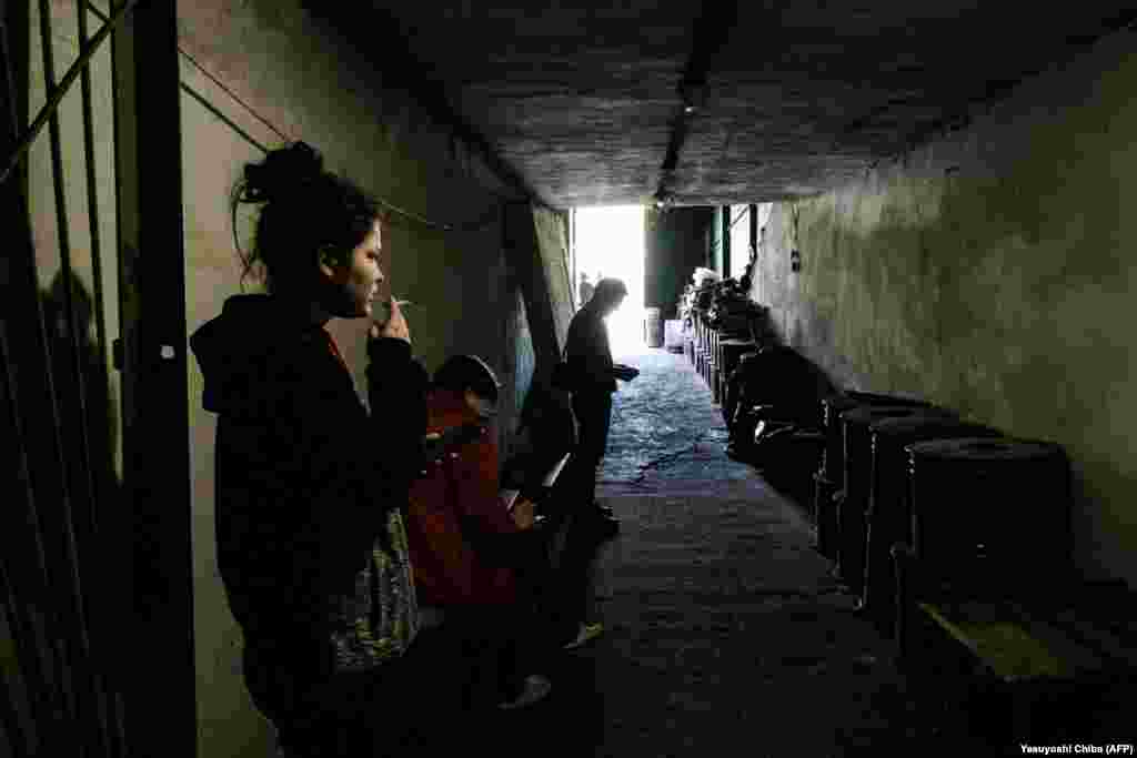 A woman smokes in the safety of a bunker that is serving as a bomb shelter in Severodonetsk on April 27. 