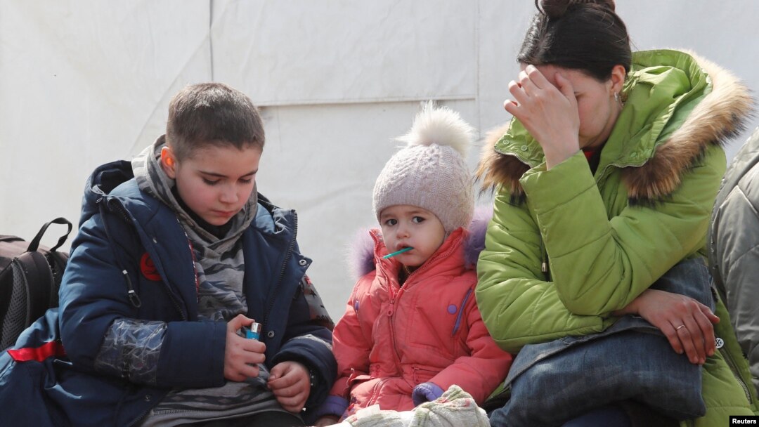 A woman sits with children as evacuees, including civilians who left the area near Azovstal steel plant in Mariupol, arrive at a temporary accommodation center in the Donetsk region in May.