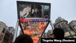 A giant screen shows news footage of Chinese President Xi Jinping visiting the Xinjiang Uyghur Autonomous Region at a shopping center in Beijing in 2022.