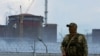 A serviceman with a Russian flag on his uniform stands guard near the Zaporizhzhia nuclear power plant in Ukraine on August 4, 2022.