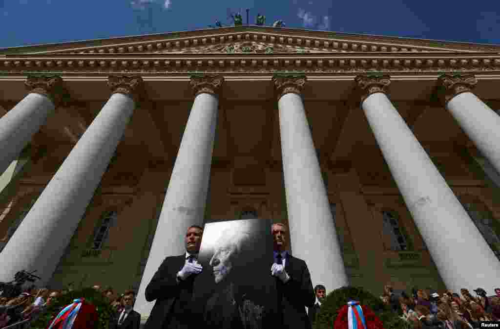 People gather outside the Bolshoi Theater in Moscow during a memorial ceremony for Russian ballet choreographer Yury Grigorovich, who recently died aged 98.