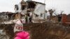 Дитина біля воронки, яка залишилася внаслідок російського ракетного удару у Глевасі на Київщині, 26 січня 2023 року