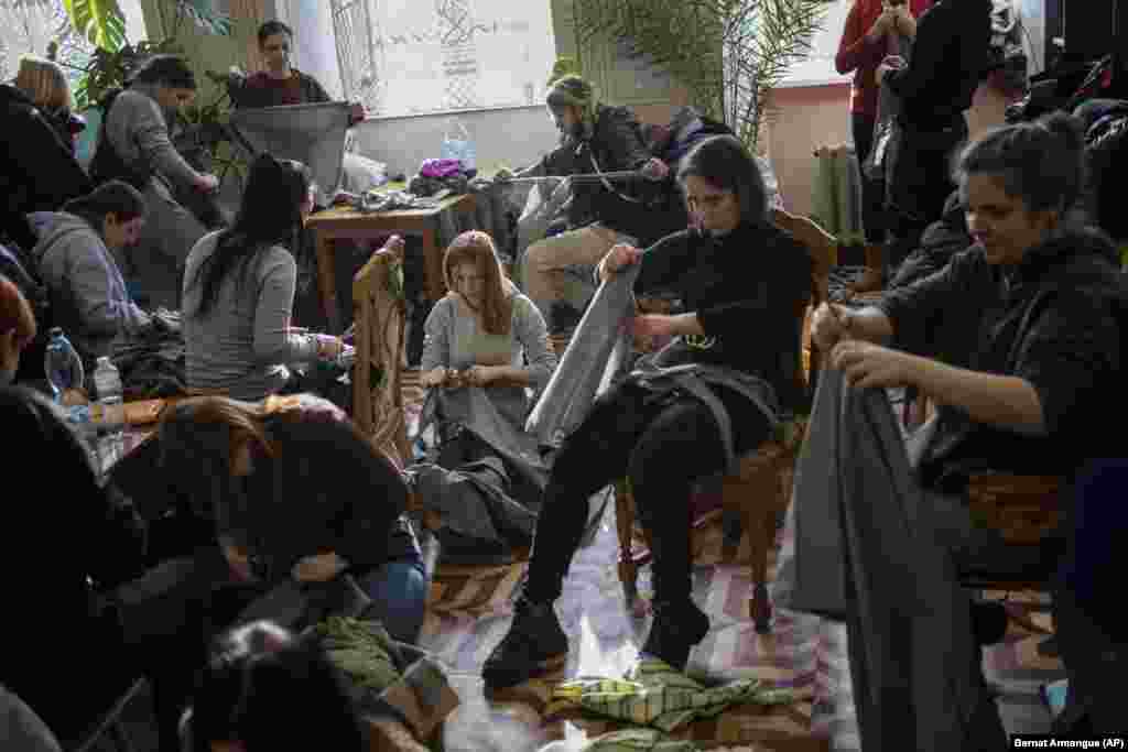 Ukrainian volunteers tear cloth into strips to make camouflage nets in Lviv on February 28.