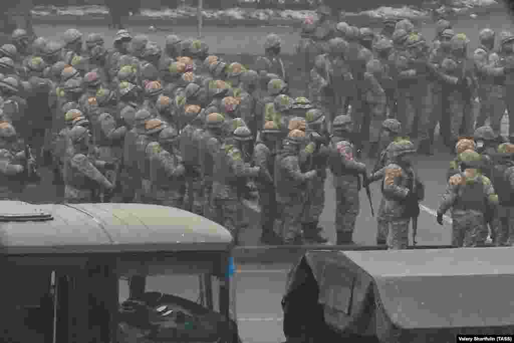 Scores of unidentified soldiers gather as gunfire rings out in central Almaty on January 6. 