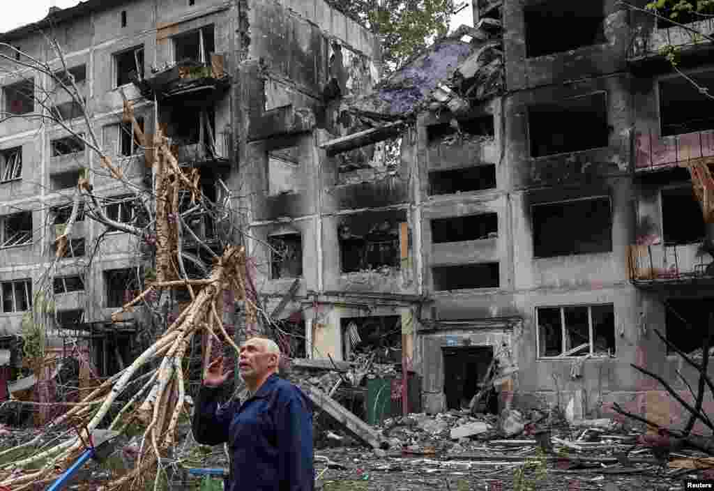 A local resident gestures as he stands near buildings damaged by Russian military strikes in the frontline town of Myrnohrad in Ukraine's Donetsk region.