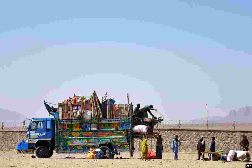 Afghan refugees unload their belongings from a truck upon arriving back from Pakistan in Kandahar Province.