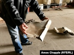 A member of the Milovice Aeroclub holds pieces of a Soviet fighter plane, which he says was destroyed with explosives during the departure of the Soviet military 35 years ago.