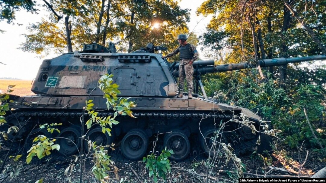 Український боєць стоїть на російській самохідній гаубиці 2С19 «Мста-С», захопленій під час наступу ЗСУ на Харківщині, 12 вересня 2022 року