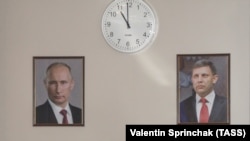 Портрети живого президента Росії Володимира Путіна і вбитого ватажка угруповання «ДНР» Олександра Захарченка під час брифінгу в день загибелі цього ватажка. Окупований Донецьк, 31 серпня 2018 року 