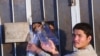 An Afghan man takes empty water bottles from Afghan men in Iranian detention in the southeastern Iranian city of Zahedan (file photo). Afghan officials say more than 5,600 Afghan nationals are in Iranian prisons for alleged drug crimes.