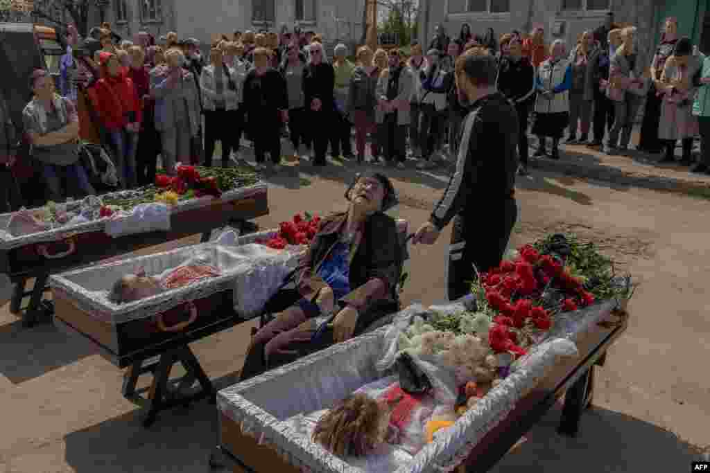 Relatives, friends, and other mourners, including the grandmother (center) of Maksym Martynenko, 11, attend his funeral and that of his parents. The family died in the Russian missile strike on Sumy on April 13, which killed 35 people.