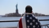 U.S. -- Ecuadoran immigrant Diego Cazar looks toward New York's Statue of Liberty during immigration-reform march on 06Apr2013