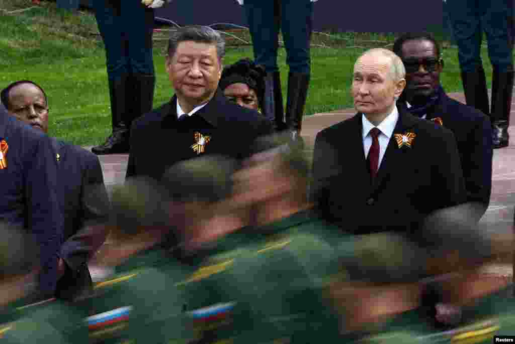 Russian President Vladimir Putin and Chinese President Xi Jinping watch Russian soldiers marching past during a flower-laying ceremony at the Tomb of the Unknown Soldier on May 9.