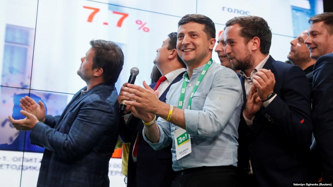 Ukrainian President Volodymyr Zelenskiy (center) reacts at his party's headquarters in Kyiv as parliamentary results come in on July 21. 