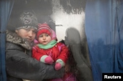 A woman and a child look through a bus window before being evacuated from Debaltseve.