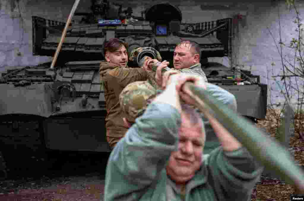 Ukrainian soldiers prepare a T-80 tank captured from Russian troops in the Donetsk region.