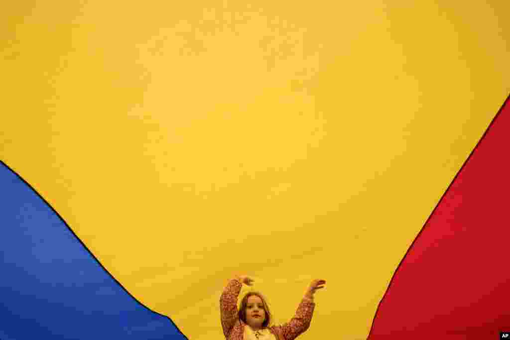 A child plays under a large Romanian flag during a pro-EU rally in Bucharest on May 9 ahead of the second round of a controversial presidential election rerun.