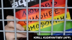 Aktivist za prava homoseksualaca drži poster s natpisom "Ljubav je jača od homofobije" u policijskom kombiju nakon pritvaranja na skupu u Moskvi, 2013. godina