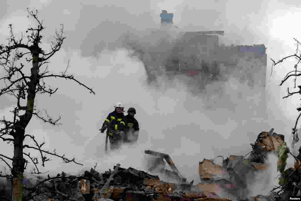 Emergency workers in Kyiv extinguish a fire in the rubble of a private house that was destroyed in a rocket strike amid a massive Russian air attack on Ukraine on May 25.