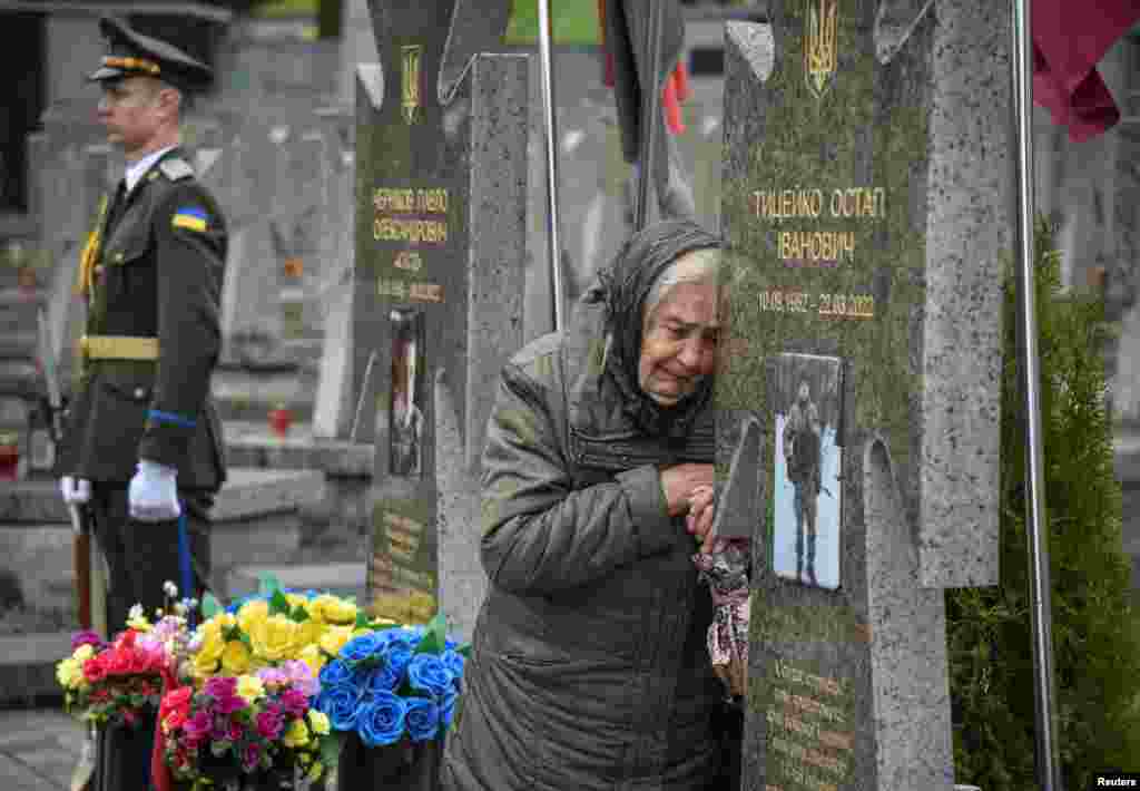A woman reacts as she visits the grave of her relative at a cemetery in Lviv as Ukrainians mark their country's Day of Heroes on May 23, a day which commemorates those who died for Ukraine's independence.