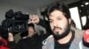 Reza Zarrab, a dual citizen of Turkey and his native Iran, is surrounded by journalists as he arrives at a police center in Istanbul in December 2013. Will his U.S. trial expose facts Turkey's president would rather not be made public?