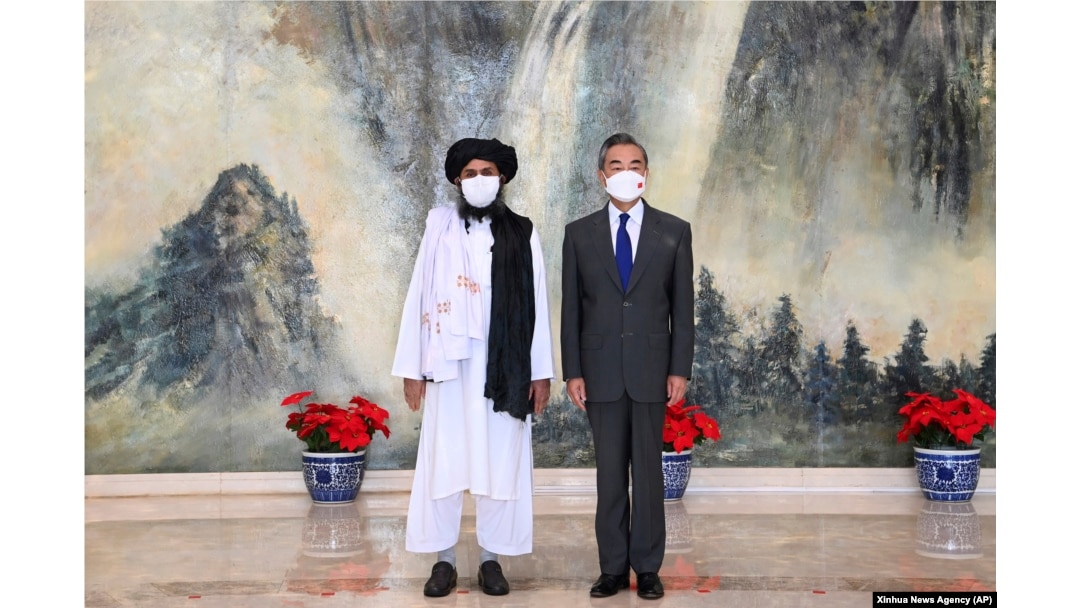 Taliban co-founder Mullah Abdul Ghani Baradar (left) and Chinese Foreign Minister Wang Yi pose for a photo in Tianjin on July 28.