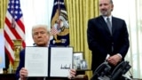US President Donald Trump holds an executive order about tariffs increase while flanked by Commerce Secretary Howard Lutnick in Washington.