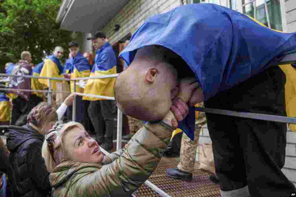 A Ukrainian soldier kisses a hand of a woman after returning from captivity in a POW exchange in Ukraine on May 6.