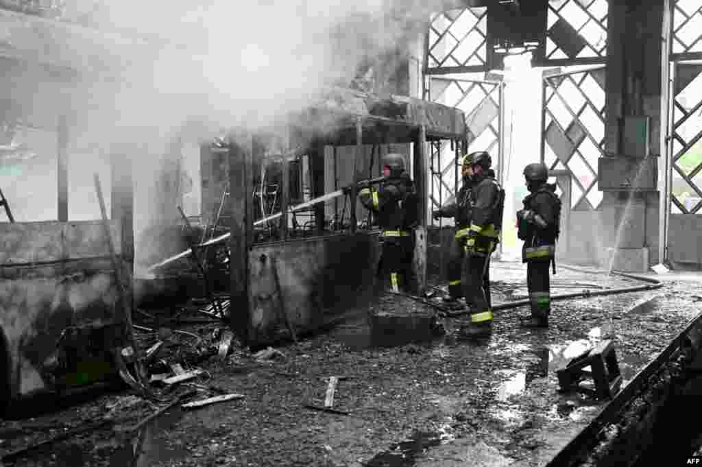 Ukrainian emergency workers extinguish a fire in a trolleybus depot following a Russian drone drone strike on Kharkiv.
