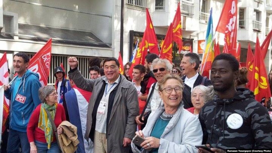 В центре, с поднятым кулаком, — казахстанский правозащитник и журналист Рамазан Есергепов участвует в одном из общественно-политических мероприятий. Париж, конец лета — осень 2017 года.  