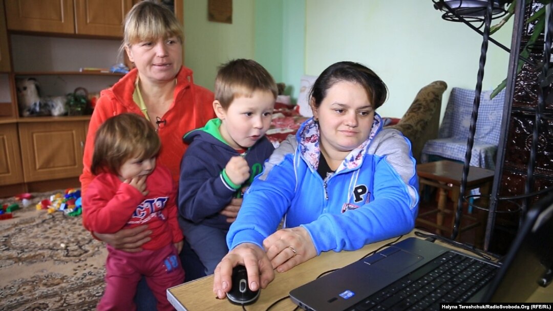 Галина і Мар’яна Трофанюки з дітьми переглядають фотографії з Майдану