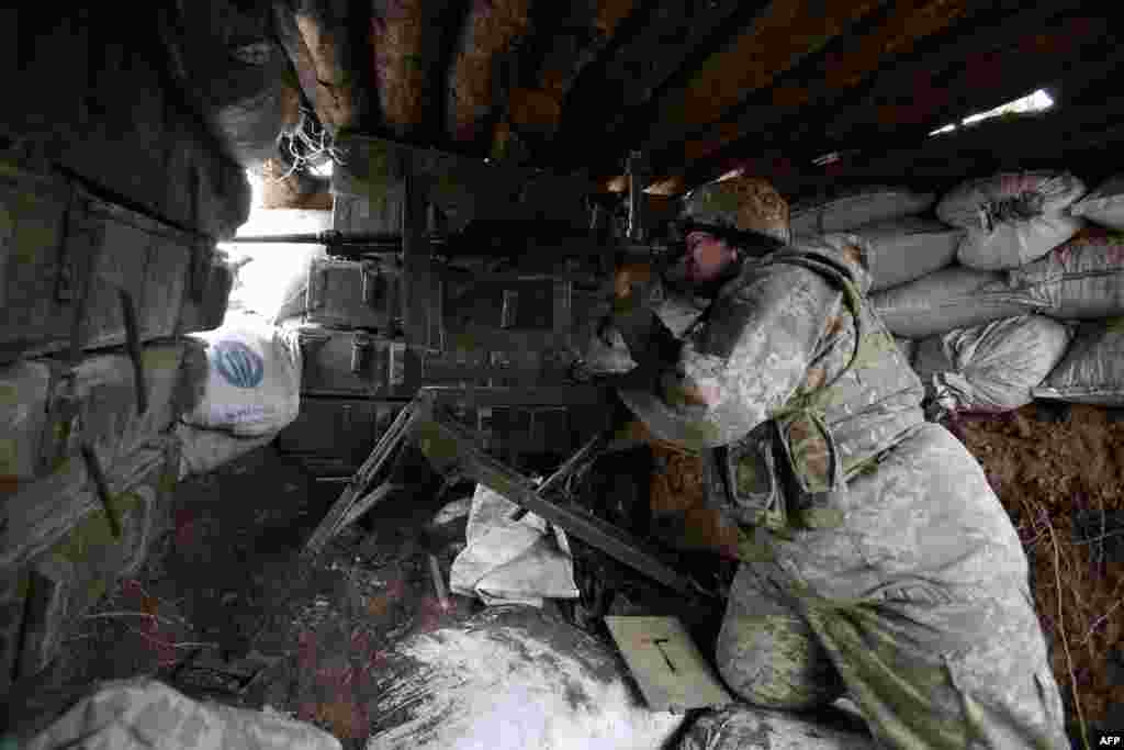 A soldier looks out from a bunker controlled by Ukrainian government forces near Avdiyivka in the Donetsk region on April 5.