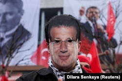 A protester wearing a cutout mask of Istanbul Mayor Ekrem Imamoglu