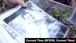 Vladyslav Popovych's mother shows Current Time a photo of her son. He is still in prison in Russia, three years after being taken by Russian troops in the Ukrainian city of Bucha. 
