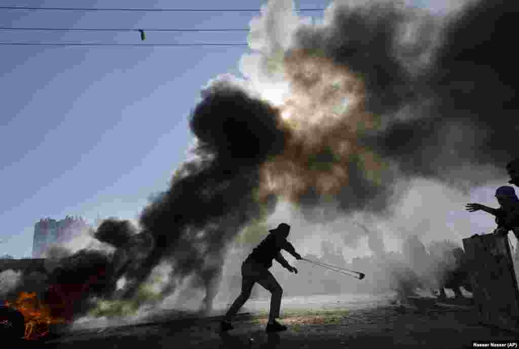Palestinci pale gume u toku sukoba sa izraelskom snagama u Ramali na Zapadnoj obali, tokom protesta protiv odluke predsednika SAD da prizna Jerusalim kao glavni grad Izraela, 8. decembar 2017. (AP/Nasser Nasser)
