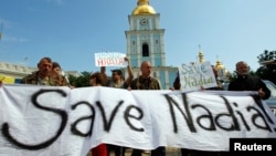 Demonstrators hold signs and banners demanding the release of Nadiya Savchenko, during a rally in Kyiv on July 11.
