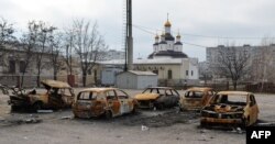 Burned cars are seen after shelling near a church in the southeastern city of Mariupol on February 25.