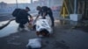 Police officers cover a dead body after two guided bombs hit a large construction supplies store in Kharkiv on May 25.