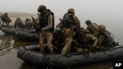 A group of Ukrainian marines sail from the riverbank of the Dnieper at the front line near Kherson on October 14.